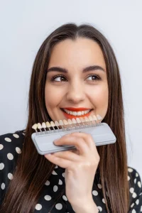 The shade selection is being shown to a patient who had porcelain veneers in Mecidiyeköy