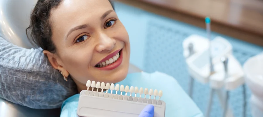 Mecidiyeköy porselen diş kaplama için renk tonlarını karşılaştıran kadın